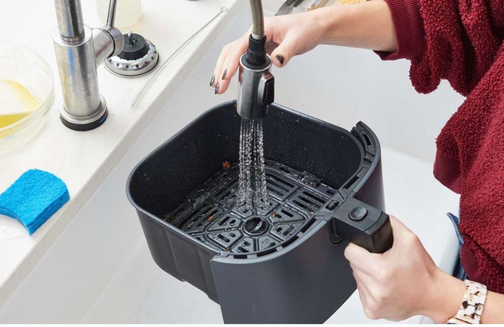 Tháo rời khay nướng, ngâm nước ấm pha xà phòng 10 - 15 phút